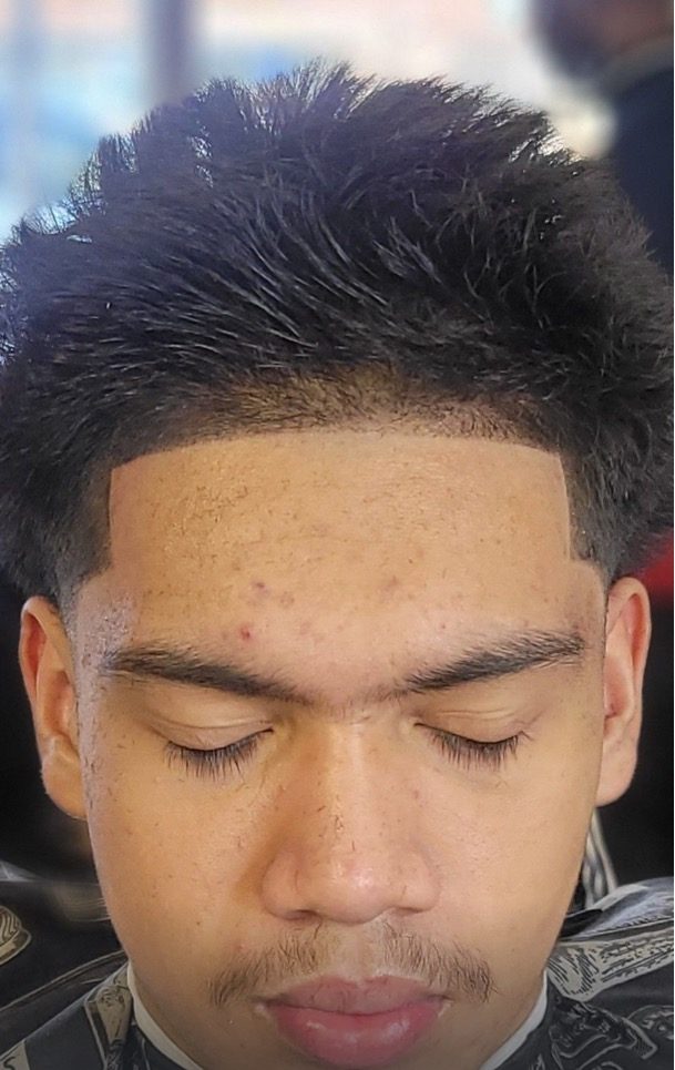 Textured top with a clean taper fade and a straight-razor line-up